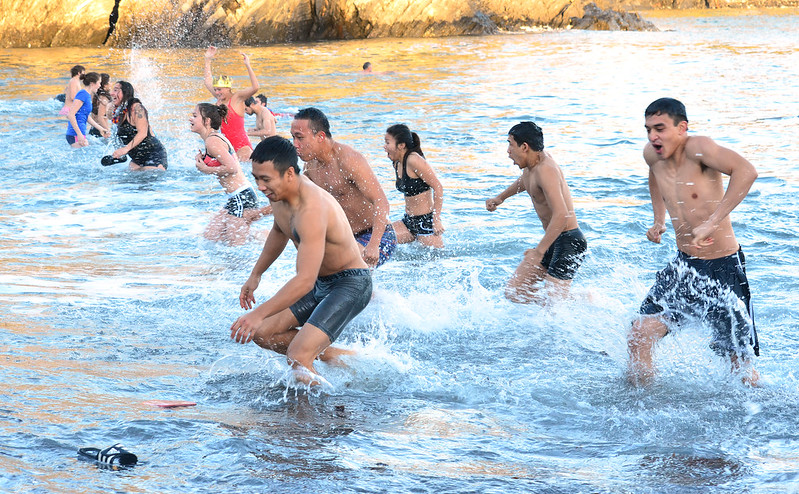crowd of people running into icy ocean water