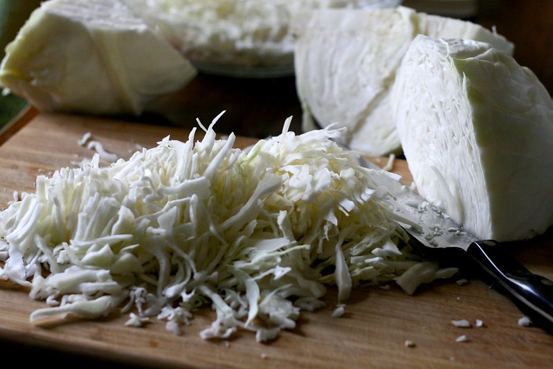 thinly sliced head cabbage on a cutting board