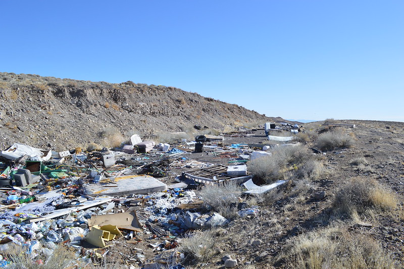 piles of trash strewn on a hill