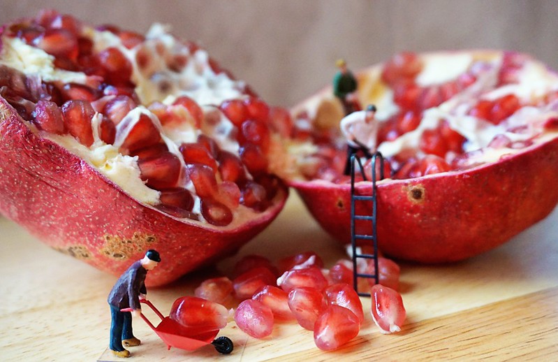 action figures "harvesting" pomegranate seeds; adds humor