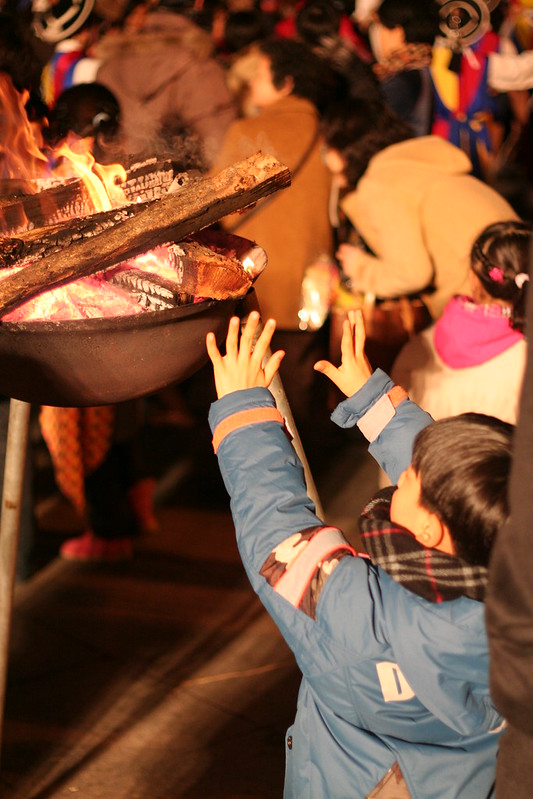 child warming hands before a fire pot illustrates Seeger's influence