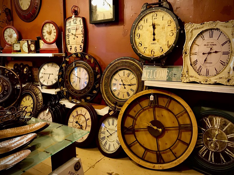 antique wall clocks on display in a shop