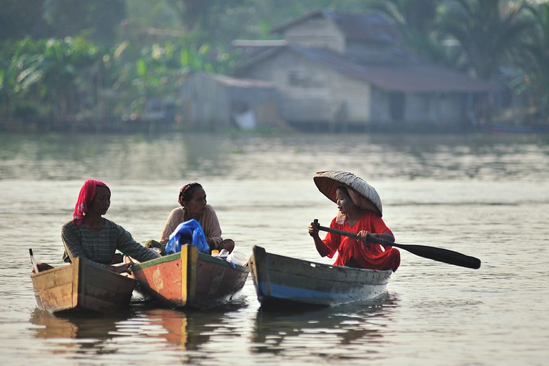 three women in canoes on a river