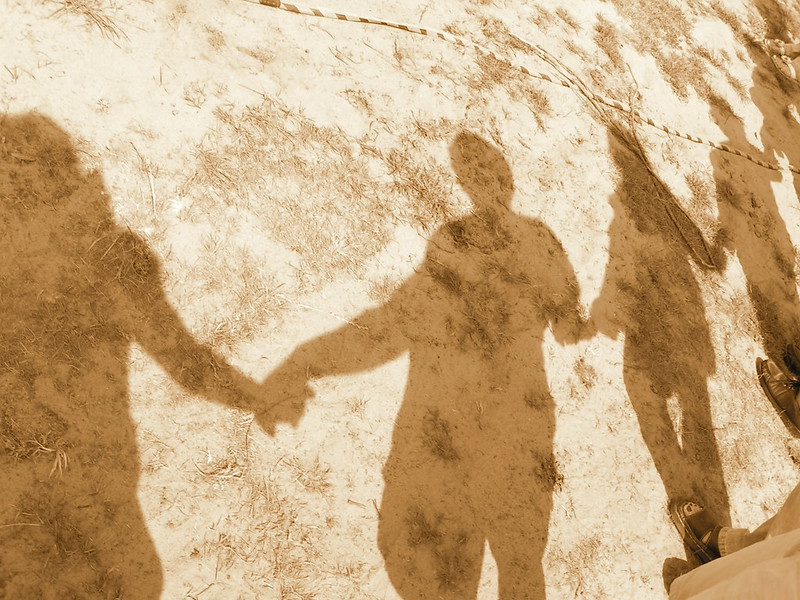 shadows of people holding hands 