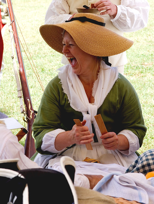 woman in a hat under a tent laughing