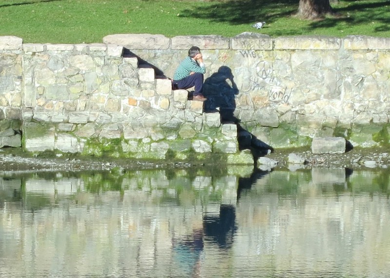person sitting on steps that lead to a river